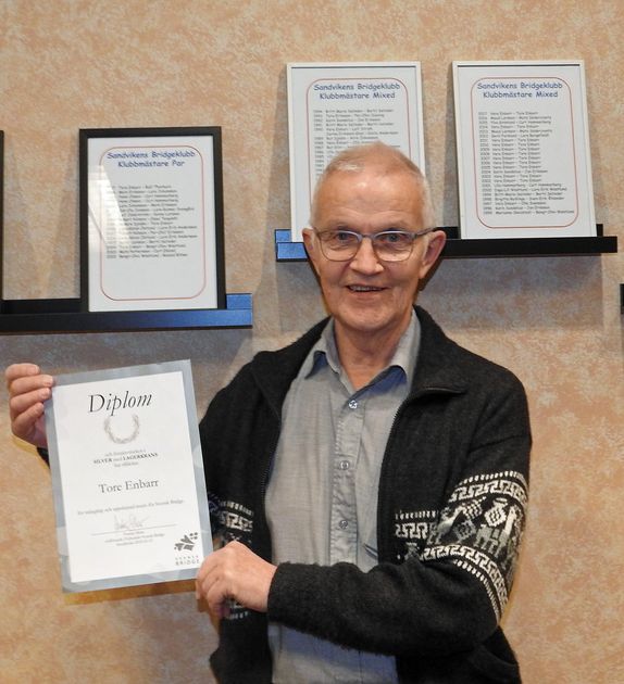 Tore håller i förtjänsttecknet i silver med lagerkrans.